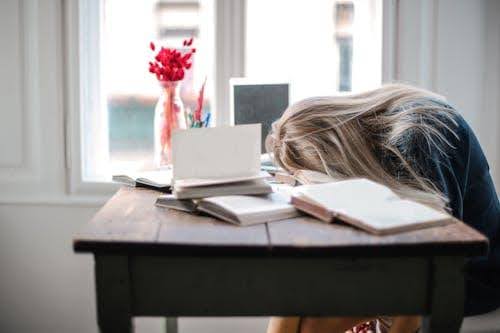 Woman in need of more restorative sleep head down at desk.